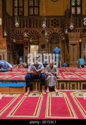 Studenti che studiano nel qibla iwan della moschea madrasa Complesso del sultano al-Ghuri al Cairo Foto Stock