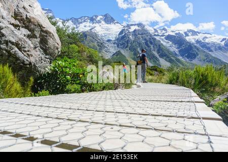 Mount Cook Nuova Zelanda - Febuary 16 2015; i turisti si fermano per guardare la vista sul passaggio pedonale in legno sulla Hooker Valley Walk a South Island, Nuova Zelanda. Foto Stock