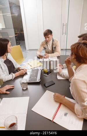 Immagine verticale di colleghi aziendali che hanno una discussione durante la riunione camera Foto Stock