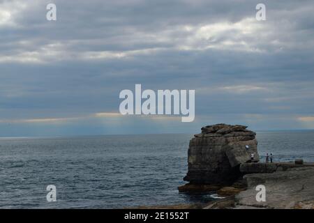 I turisti si arrampicano su Pulpit Rock a Portland Bill sull'isola di Portland, Dorset Foto Stock