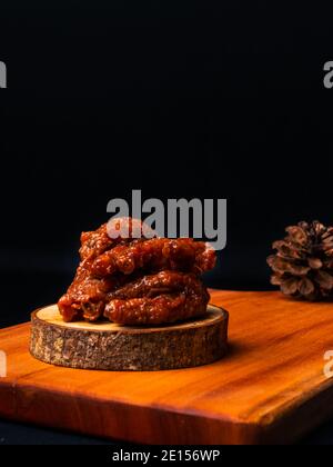 phoenix artiglio dim sum su un piatto di legno su uno sfondo scuro. prendere il phoenix artiglio dim sum con bastoncini Foto Stock