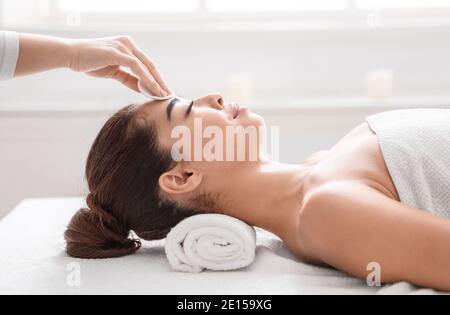 Trattamento viso. Cosmetologo professionista pulizia della pelle della donna asiatica prima delle procedure di bellezza Foto Stock