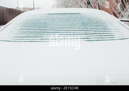 Il ghiaccio si fonde sul lunotto della vettura - riscaldamento dell'alzavetro elettrico con strisce di contatto Foto Stock