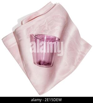 Vetro rosa e tovagliolo in tessuto fotografato su sfondo bianco Foto Stock