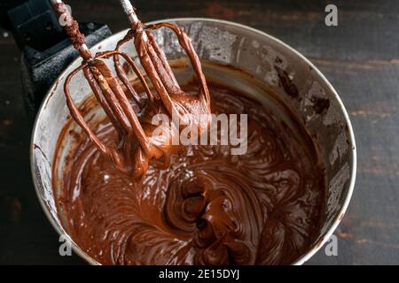 Fare glassa di cioccolato in uno Stand Mixer: Torta di cioccolato glassa che è stato appena fatto in un mixer elettrico stativo Foto Stock