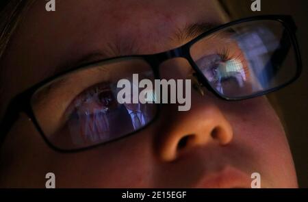 Loughborough, Leicestershire, Regno Unito. 4 gennaio 2021. Una ragazza guarda una trasmissione dal vivo dal primo ministro BritainÕs Boris Johnson mentre annuncia un blocco nazionale dopo un grande aumento dei casi di coronavirus. Credit Darren Staples/Alamy Live News. Foto Stock