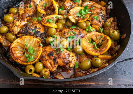 Pollo marocchino al limone d'oliva: Cosce di pollo, olive e limoni cotti in una padella di ghisa Foto Stock