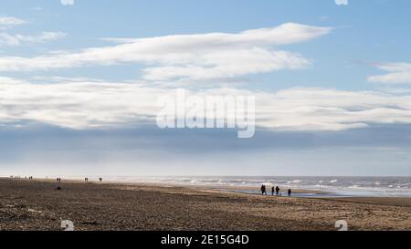 Le famiglie si sono silhouette al sole sulla spiaggia di Formby vicino a Liverpool nel gennaio 2021. Foto Stock