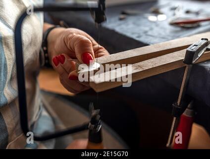 donna che lavora su una panchina in un'officina di produzione di gioielli Foto Stock