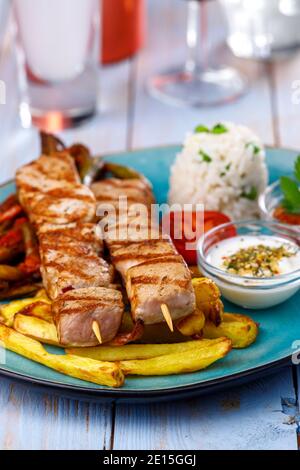 spiedini di souvlaki greci con patatine fritte Foto Stock