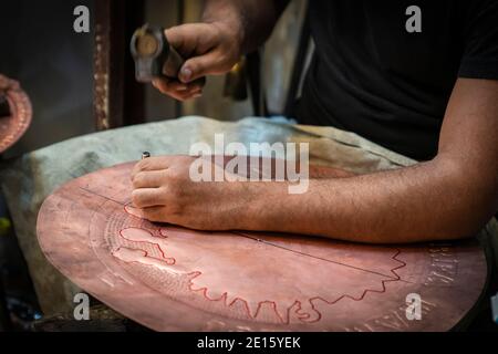 Un Coppersmith busily che fa una piastra di rame in Bazaar di rame-Sanliurfa-Turchia Foto Stock