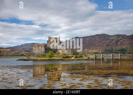 Western Highlands, Scozia: Castello di Eileen Donan e riflessioni sotto il cielo nuvoloso, Kintail National Scenic Area Foto Stock