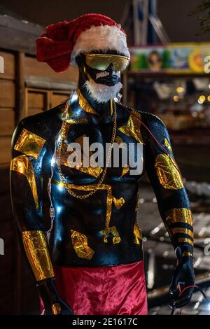 Manichino di un uomo nero in cappello rosso e santaclaus pantaloncini e gerlands Foto Stock