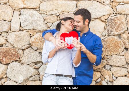 Giovane coppia abbracciando, baciandosi e godendosi passare il tempo insieme mentre festeggia San Valentino nella campagna. Amore san valentin e R. Foto Stock
