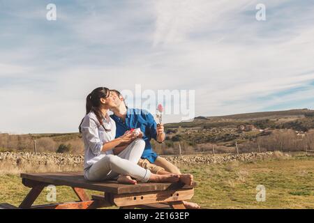 Giovane coppia abbracciando, baciandosi e godendosi passare il tempo insieme mentre festeggia San Valentino nella campagna. Amore san valentin e R. Foto Stock