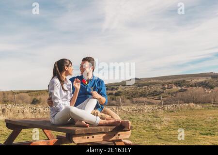 Giovane coppia abbracciando, baciandosi e godendosi passare il tempo insieme mentre festeggia San Valentino nella campagna. Amore san valentin e R. Foto Stock