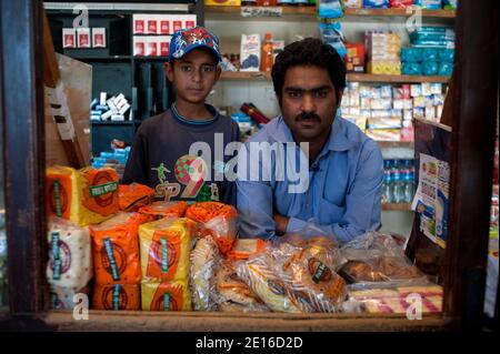 Anjum (R) pone ad Abbottabad, in Pakistan, il 2 maggio 2011, nella drogheria accanto alla casa di Osama Bin Laden, dove gli habitat della casa abituati a fare acquisti di generi alimentari. Anjum ha visto passare ogni mattina i bambini della casa accompagnati da auto a scuola. Foto di Julien Fouchet/ABACPARESS.COM Foto Stock