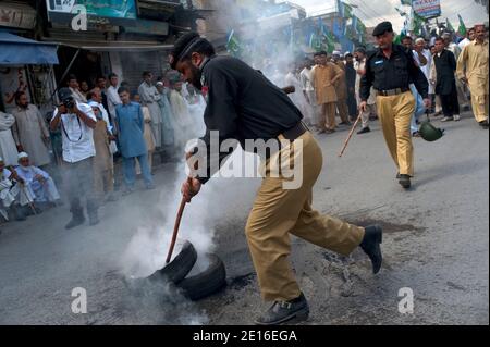 La gente gridò slogan e brucia pneumatici durante una protesta organizzata dal partito religioso Giamaat-e-Islami, il 6 maggio 2011, ad Abbottabad, Pakistan. Forze d'élite AMERICANE Navy Seals operò un raid, il 2 maggio, su un composto situato in questa città, durante il quale uccisero il leader al Qaeda Oussama ben Laden. Foto di Julien Fouchet/ABACAPRESS.COM Foto Stock