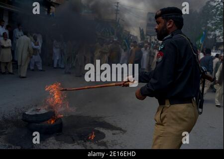 La gente gridò slogan e brucia pneumatici durante una protesta organizzata dal partito religioso Giamaat-e-Islami, il 6 maggio 2011, ad Abbottabad, Pakistan. Forze d'élite AMERICANE Navy Seals operò un raid, il 2 maggio, su un composto situato in questa città, durante il quale uccisero il leader al Qaeda Oussama ben Laden. Foto di Julien Fouchet/ABACAPRESS.COM Foto Stock