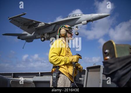 Oceano Indiano, Stati Uniti. 01 gennaio 2021. Joseph Bayo, USA Navy Lt, gestisce l'equipaggiamento di arresto del ponte di volo, come un F/A-18F Super Hornet jet da combattimento dal combattente Redcks of Strike Fighter Squadron 22, si avvicina a atterrare sul ponte di volo della portaerei di classe Nimitz USS Nimitz 1 gennaio 2021 nell'Oceano Indiano. Il Nimitz doveva tornare al porto di casa, ma è stato mantenuto in posizione vicino all'Iran a causa delle crescenti tensioni. Credit: Planetpix/Alamy Live News Foto Stock