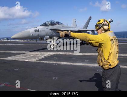 Oceano Indiano, Stati Uniti. 01 gennaio 2021. US Navy Aviation Boatswain's Mate Airman Brady Lawrence segnala un e/A-18G aereo da combattimento Growler, dal Cougars of Electronic Attack Squadron 139, si avvicina a terra sul ponte di volo della nave portaerei di classe Nimitz USS Nimitz 1 gennaio 2021 nell'Oceano Indiano. Il Nimitz doveva tornare al porto di casa, ma è stato mantenuto in posizione vicino all'Iran a causa delle crescenti tensioni. Credit: Planetpix/Alamy Live News Foto Stock