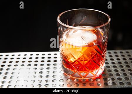 Whisky con una palla di ghiaccio in un bicchiere. Pronto a mangiare. Foto Stock