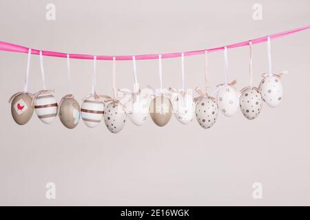 uova di pasqua appese in nastro rosa Foto Stock