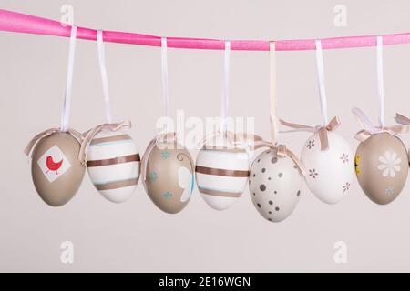 uova di pasqua appese in nastro rosa Foto Stock