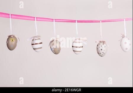 uova di pasqua appese in nastro rosa Foto Stock