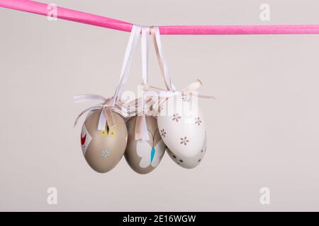 uova di pasqua appese in nastro rosa Foto Stock
