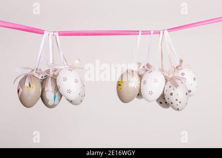 uova di pasqua appese in nastro rosa Foto Stock