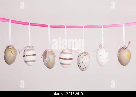 uova di pasqua appese in nastro rosa Foto Stock