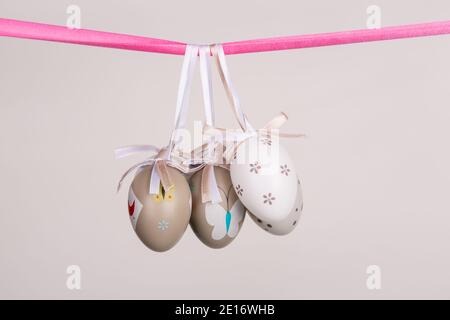 uova di pasqua appese in nastro rosa Foto Stock