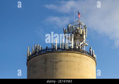 La tradizione incontra la tecnologia. 5G cellulare torre sulla cima di un vecchio fienile silo. Foto Stock