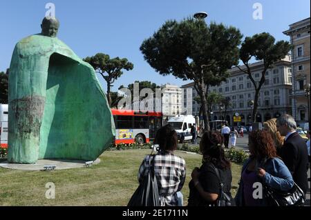 Un'enorme statua di Giovanni Paolo II, svelata di fronte alla stazione centrale poche settimane dopo che l'ex pontefice è stato messo sulla strada della santità, ha scatenato polemiche con la gente del posto che lo chiedeva di andare a Roma, Italia il 20,2011 maggio. La statua di bronzo alta cinque metri, Progettato dall'artista italiano Oliviero Rainaldi, raffigura Giovanni Paolo II con le braccia distese, riflettendo il "messaggio di accoglienza e di apertura verso gli altri" del papa. Giovanni Paolo sorride benignamente sui passanti, la sua testa di bronzo sostenuta da una struttura senza corpo, ma un grande mantello che cade a terra su tre lati, lasciando Foto Stock