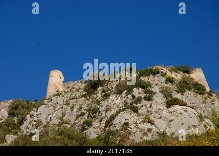 Promontorio roccioso e rovine del castello con un'aquila nel cielo sopra, vicino Benirrama, provincia di Alicante, Spagna Foto Stock