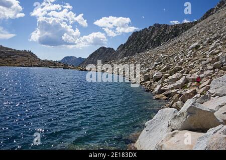 Donna escursioni intorno al bordo del Lago d'Oro nel Montagne della Sierra Nevada Foto Stock