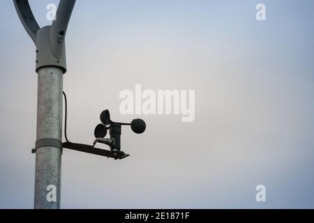Anemometro che gira e gira nel vento di fronte a un clima grigio nuvoloso. Un anemometro viene utilizzato in meteorologia per misurare la velocità del vento. Pi Foto Stock
