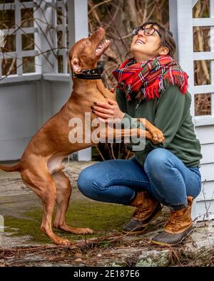 Giovane donna che gioca con il suo cane Foto Stock