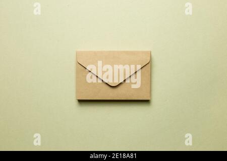 Busta di carta marrone Kraft su sfondo khaki. Vista dall'alto, spazio per la copia Foto Stock