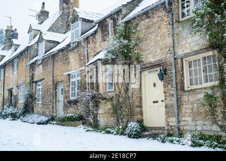 Row of Cottold Stone Cottages on Burford Hill nella neve di dicembre. Burford, Cotswolds, Oxfordshire, Inghilterra Foto Stock