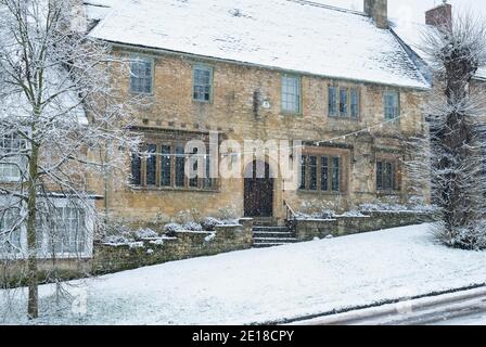 Casa di città su Burford Hill nella neve di dicembre. Burford, Cotswolds, Oxfordshire, Inghilterra Foto Stock