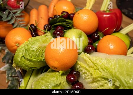 Un gruppo di frutta e verdura, tra cui un grosso arancio Foto Stock