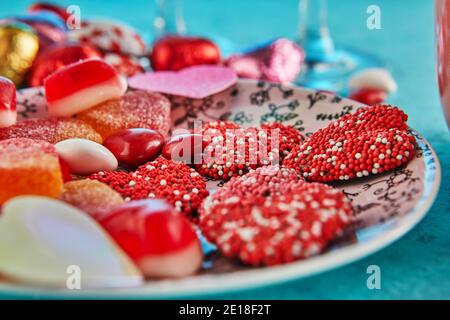 San Valentino o cena romantica con cuori di caramelle su un sfondo blu Foto Stock