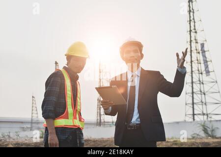 Project manager che gestisce la comunicazione tablet con Construction Engineering per il lavoro costruzione di immobili Foto Stock