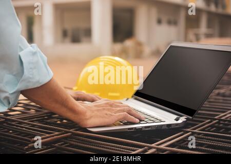 Addetto alla costruzione in primo piano che utilizza un casco per computer sul cantiere Foto Stock