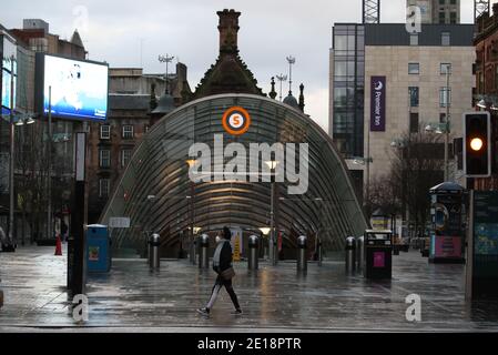 Una donna passa davanti all'ingresso della stazione della metropolitana su Buchanan Street, Glasgow, la mattina dopo che sono entrate in vigore misure di blocco più severe per la Scozia continentale. Foto Stock