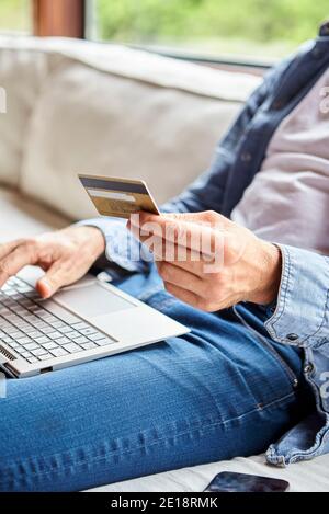 Sezione centrale dell'uomo adulto medio che effettua il pagamento in linea Foto Stock