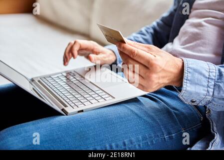 Sezione centrale dell'uomo adulto medio che effettua il pagamento in linea Foto Stock