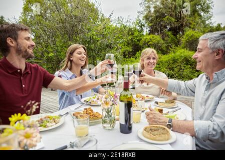 Buon bicchiere di vino da tostare con la famiglia Foto Stock